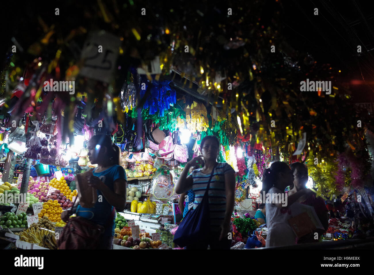 Quezon City, Philippines. 24th Nov, 2016. People walk through Christmas