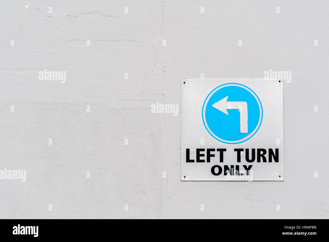Left Turn Only sign on a white wall - politics concept BHZ. Stock Photo