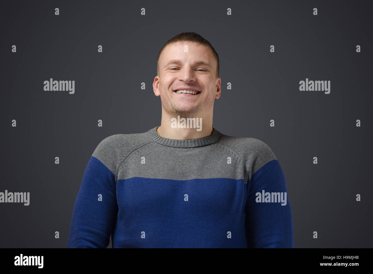 Portrait of a young gay men who smiles. Emotional photo in studio on a black background Stock Photo