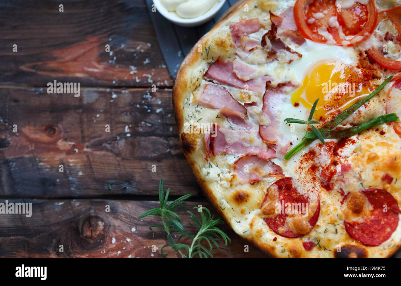 Pizza carbonara with bacon, salami, parmesan cheese and chicken egg on