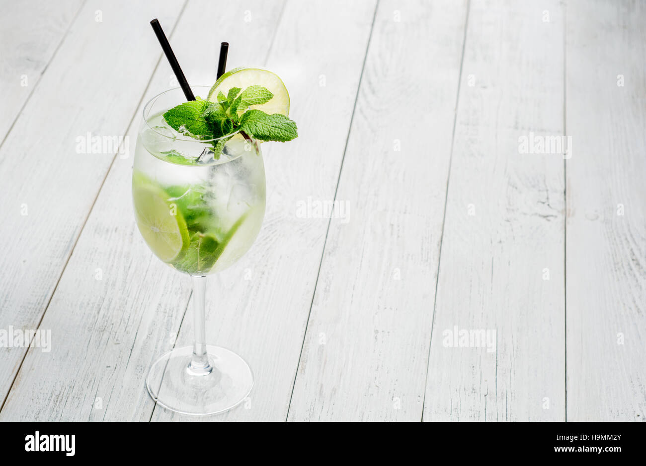 Martini royale Cocktail on wooden table with lime and mint. Stock Photo