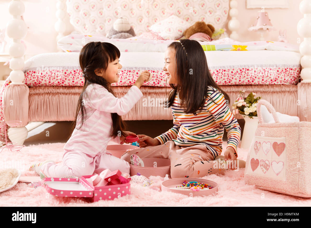 Two cute little girls play in the bedroom Stock Photo Alamy