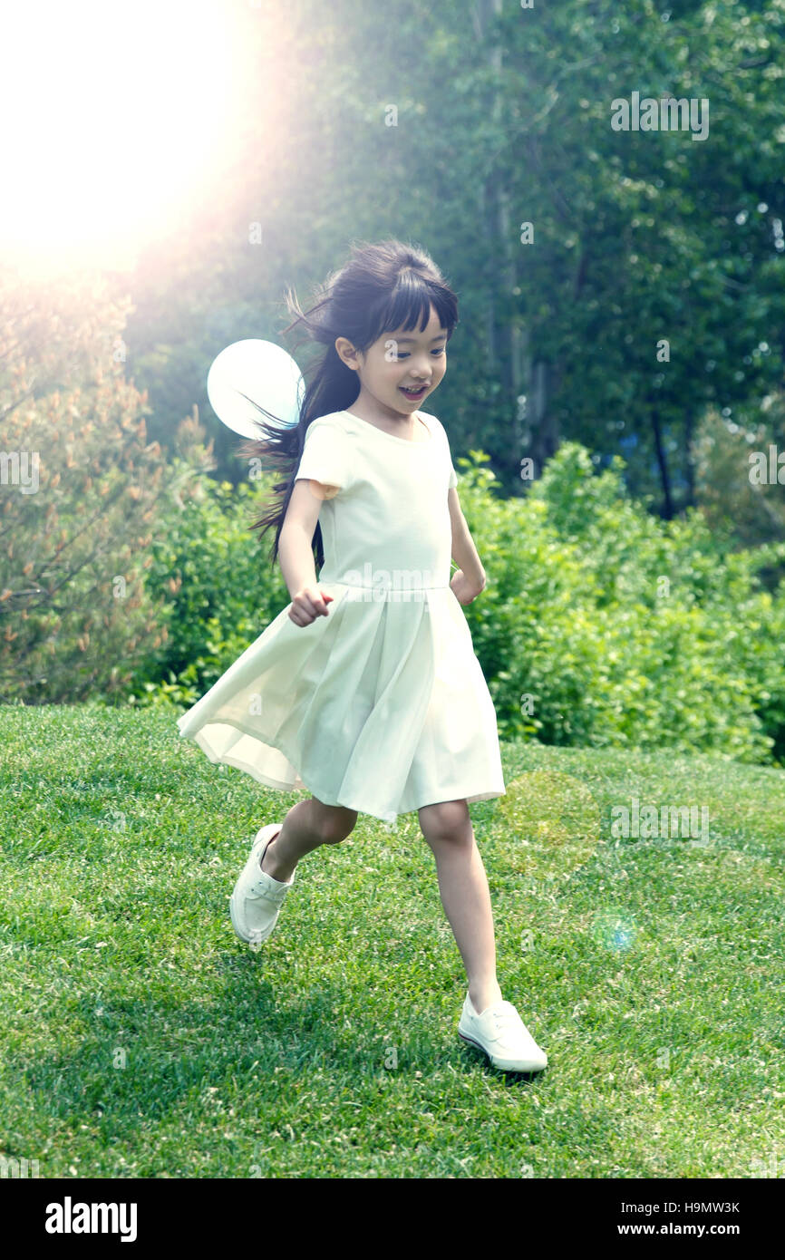 The little girl is playing on the grass Stock Photo - Alamy