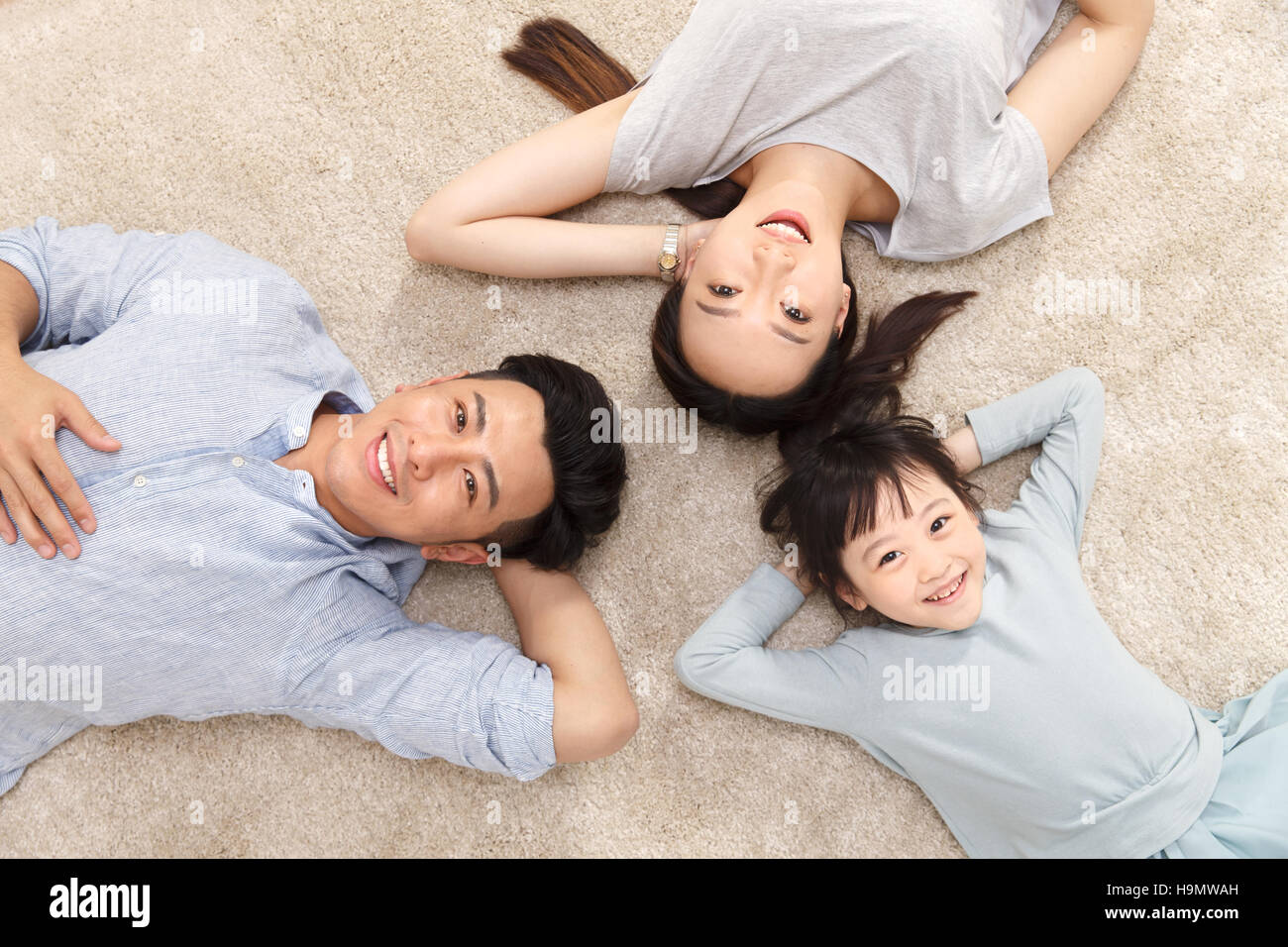 Happy family lying on the ground Stock Photo - Alamy