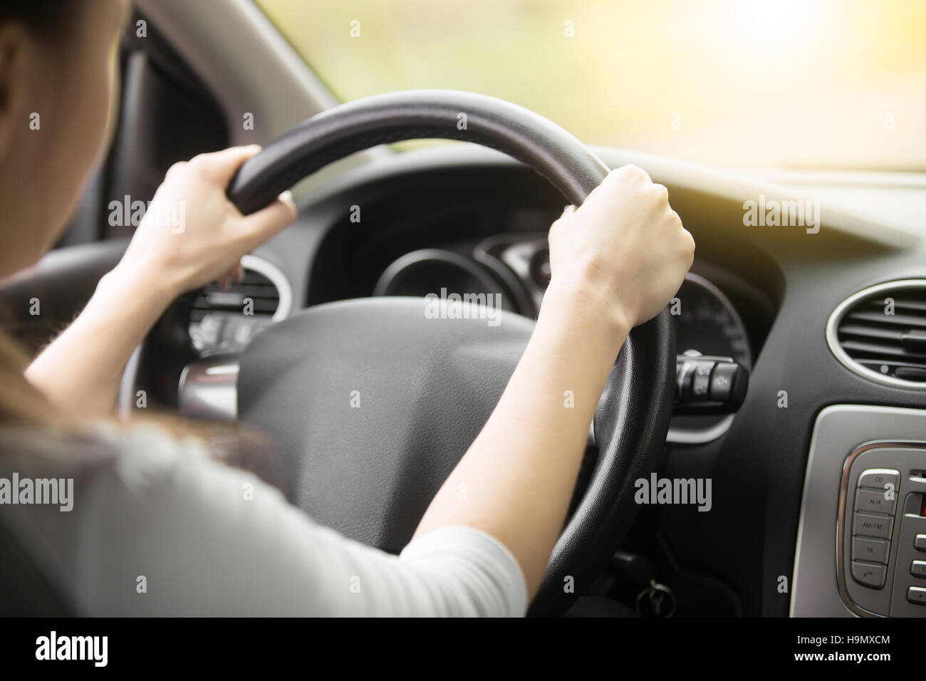 Close-up of female hands on the steering wheel Stock Photo