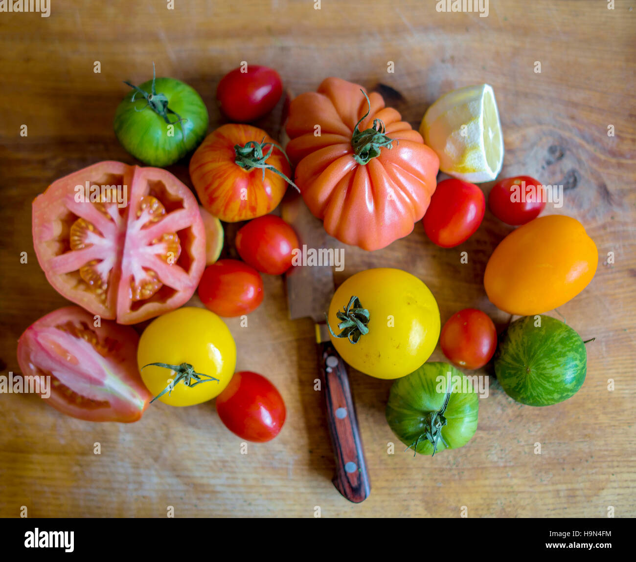 Various Tomato Varieties on Chopping Board with Knife Stock Photo - Alamy