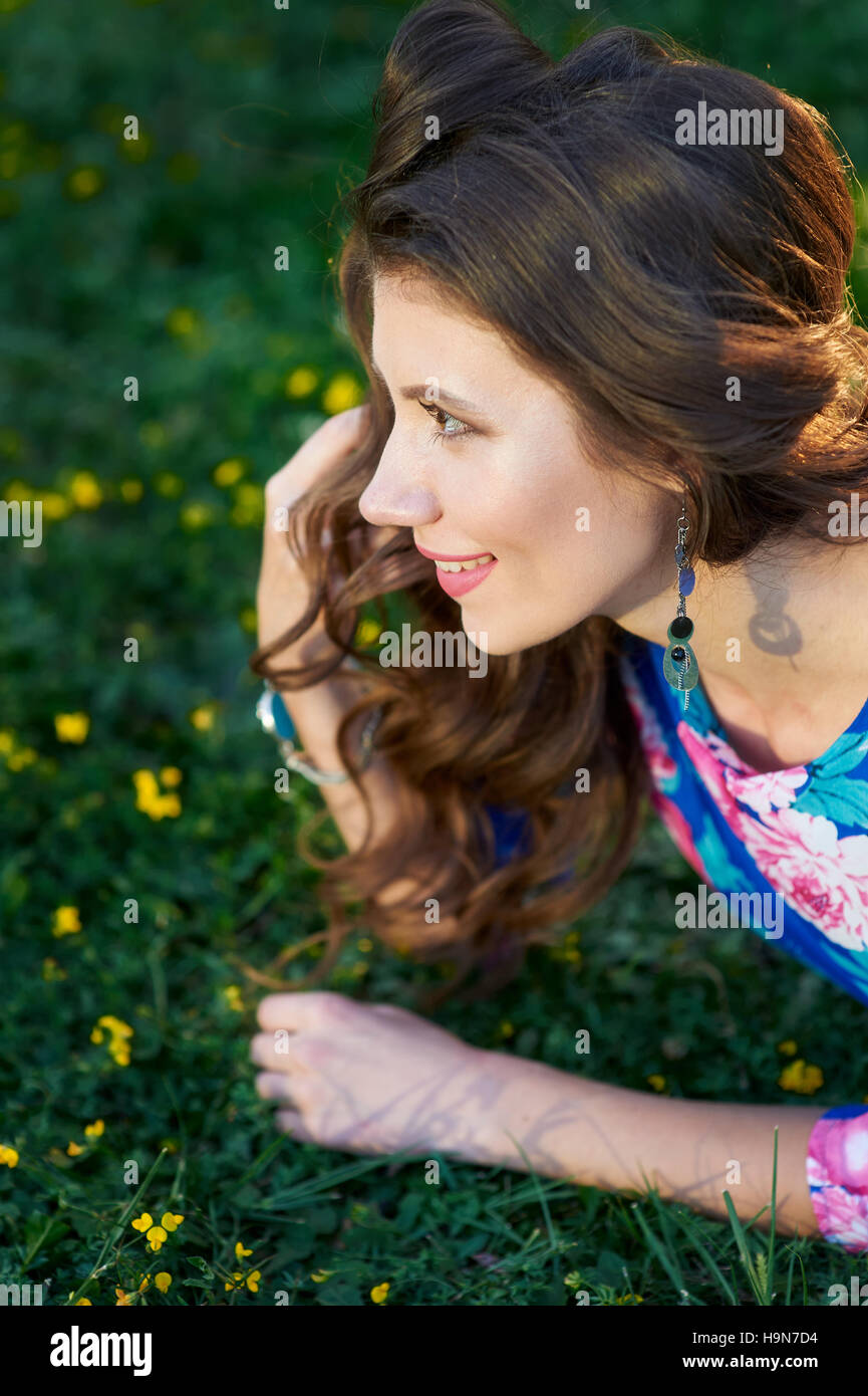 happy young woman lying on green grass Stock Photo