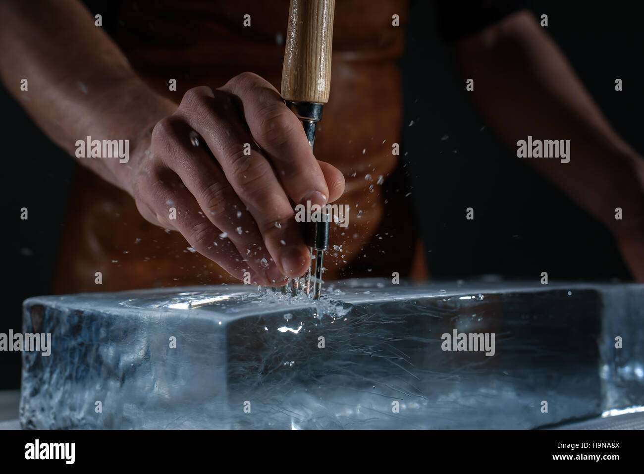 Bartender chopping ice using a special knife Stock Photo Alamy