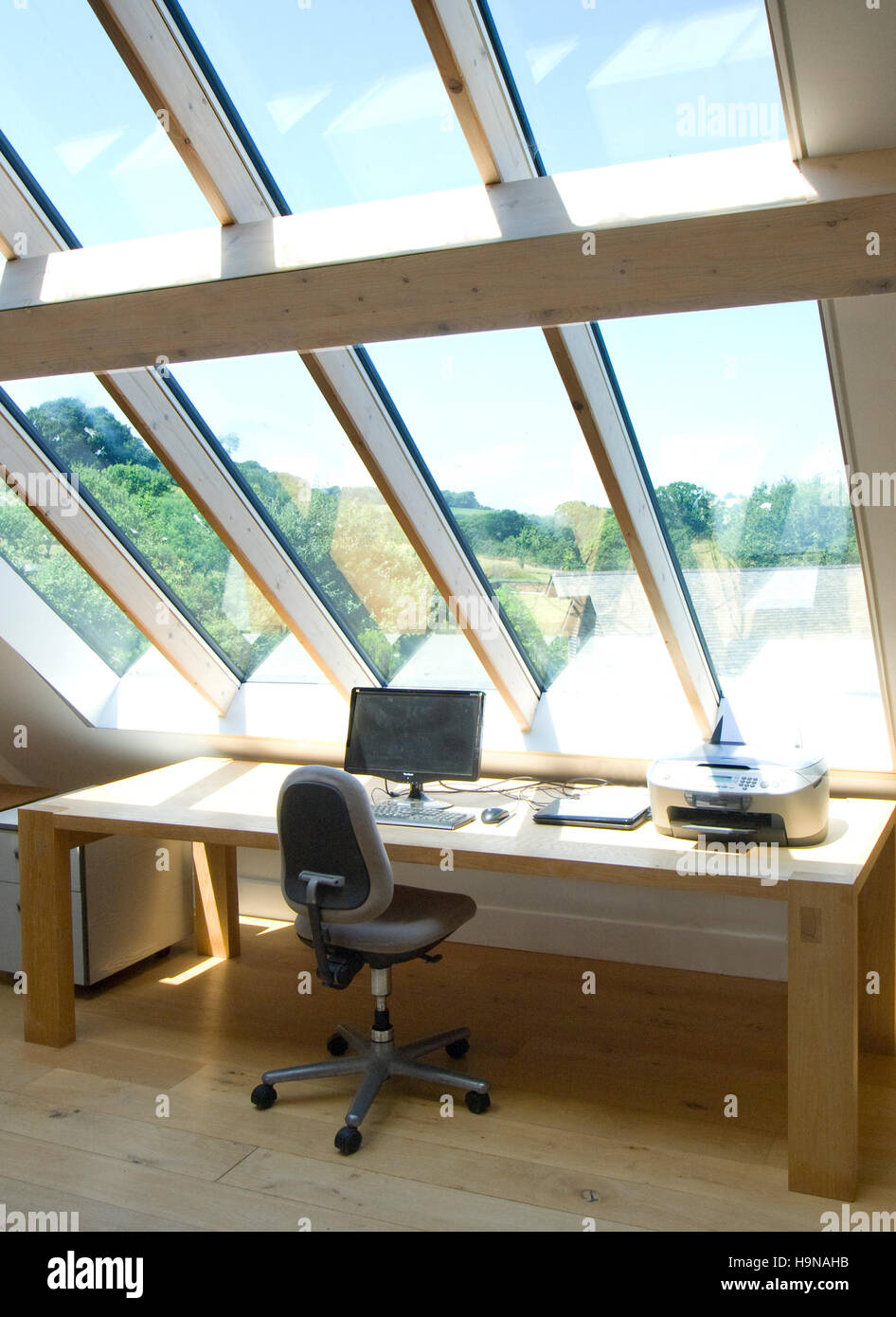 Home office, glass roof, daylight studio, workspace, desk top, study with view. Stock Photo