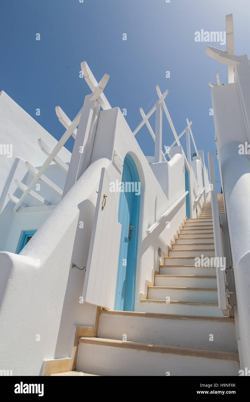 White stairway up an alley in Imerovigli, Santorini, Greece with blue doors on the sides Stock Photo