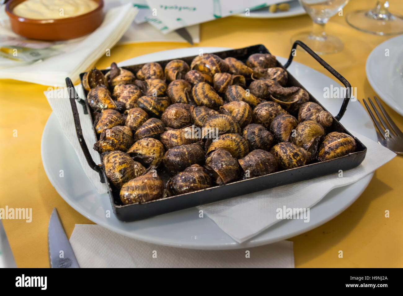Catalan traditional dish 'caragols al forn' (escargots baked in the oven) served in a restaurant in Barcelona, Catalonia, Spain. Stock Photo