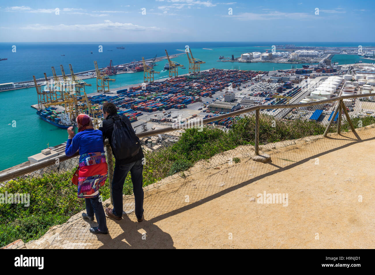 Couple looking at the container terminal of the port of Barcelona, Catalonia, Spain, from above. Stock Photo