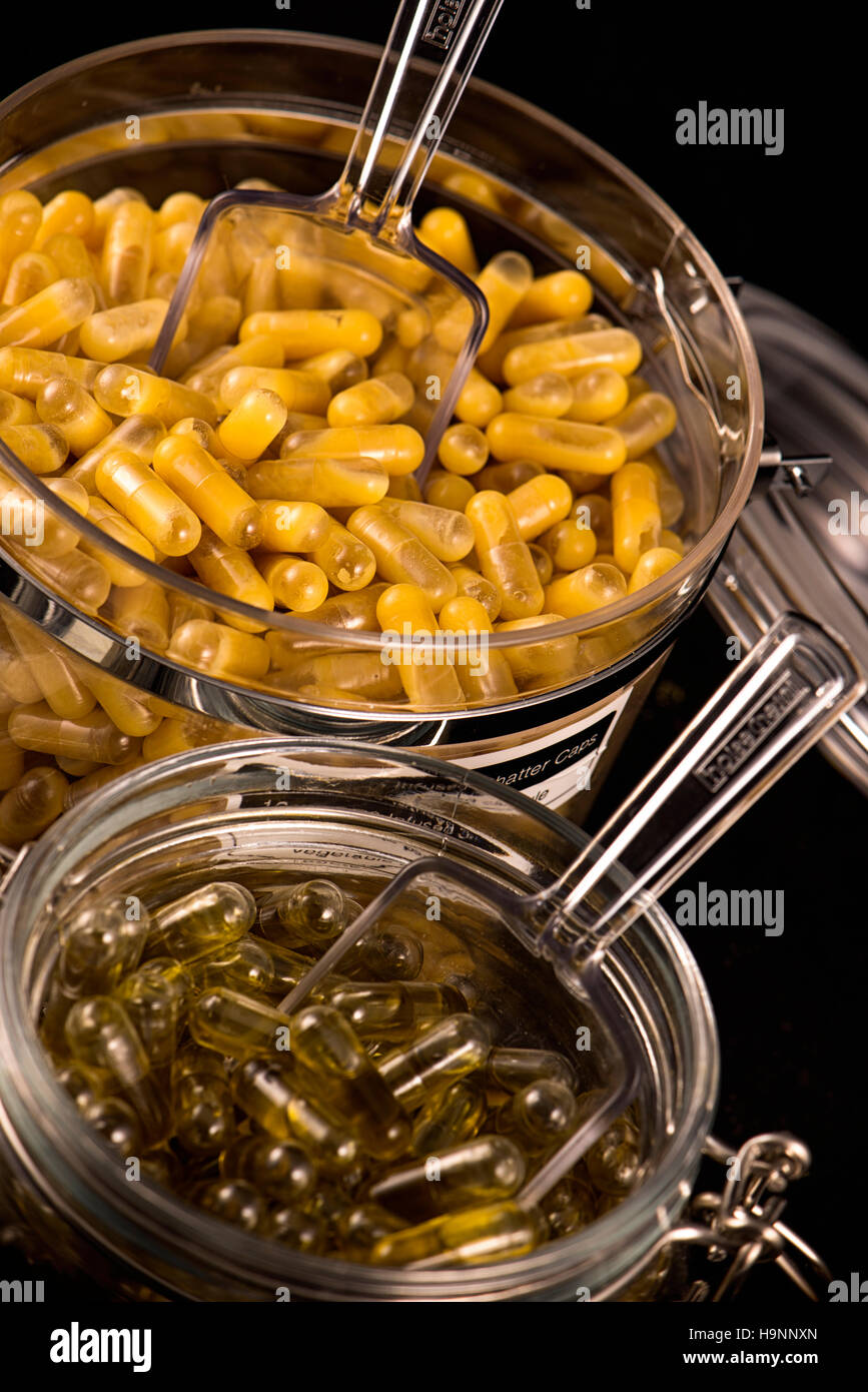 Cannabis extraction capsules infused with shatter and CBD oil isolated over black background Stock Photo
