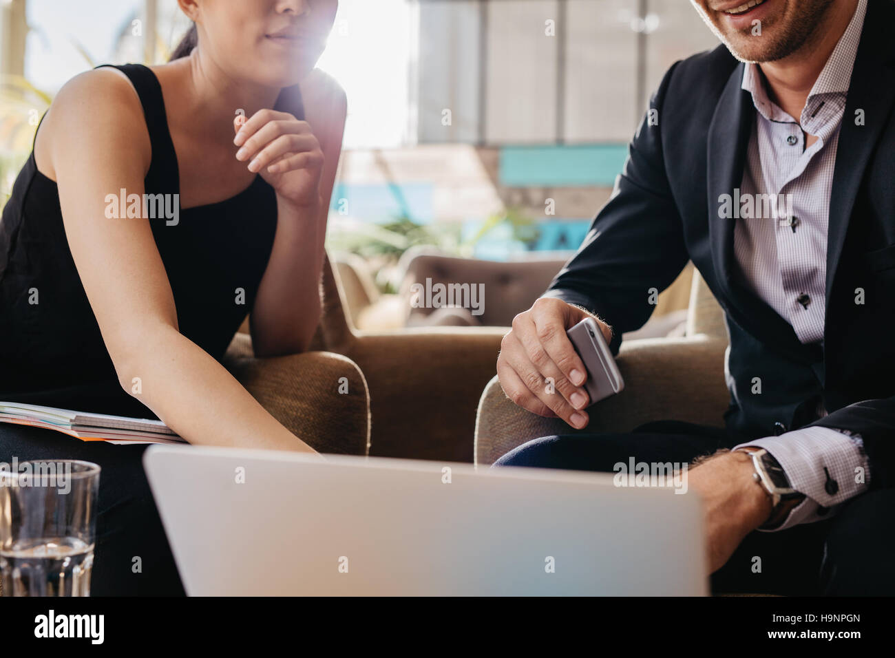 Shot of two young businesspeople sitting together working on laptop