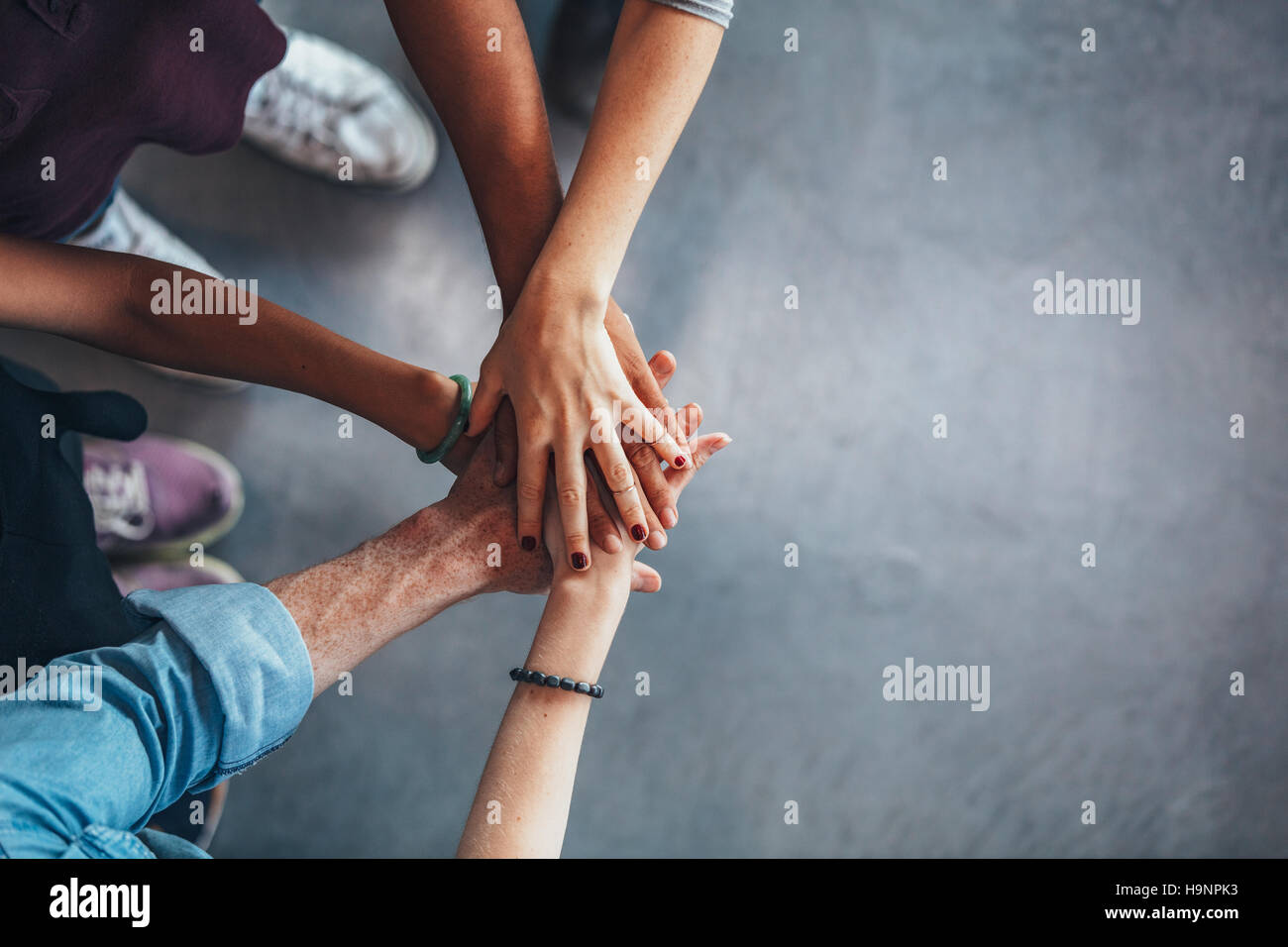 Cropped image of young people's hands on top of each other. Top view of young group with hands on stack. Stock Photo