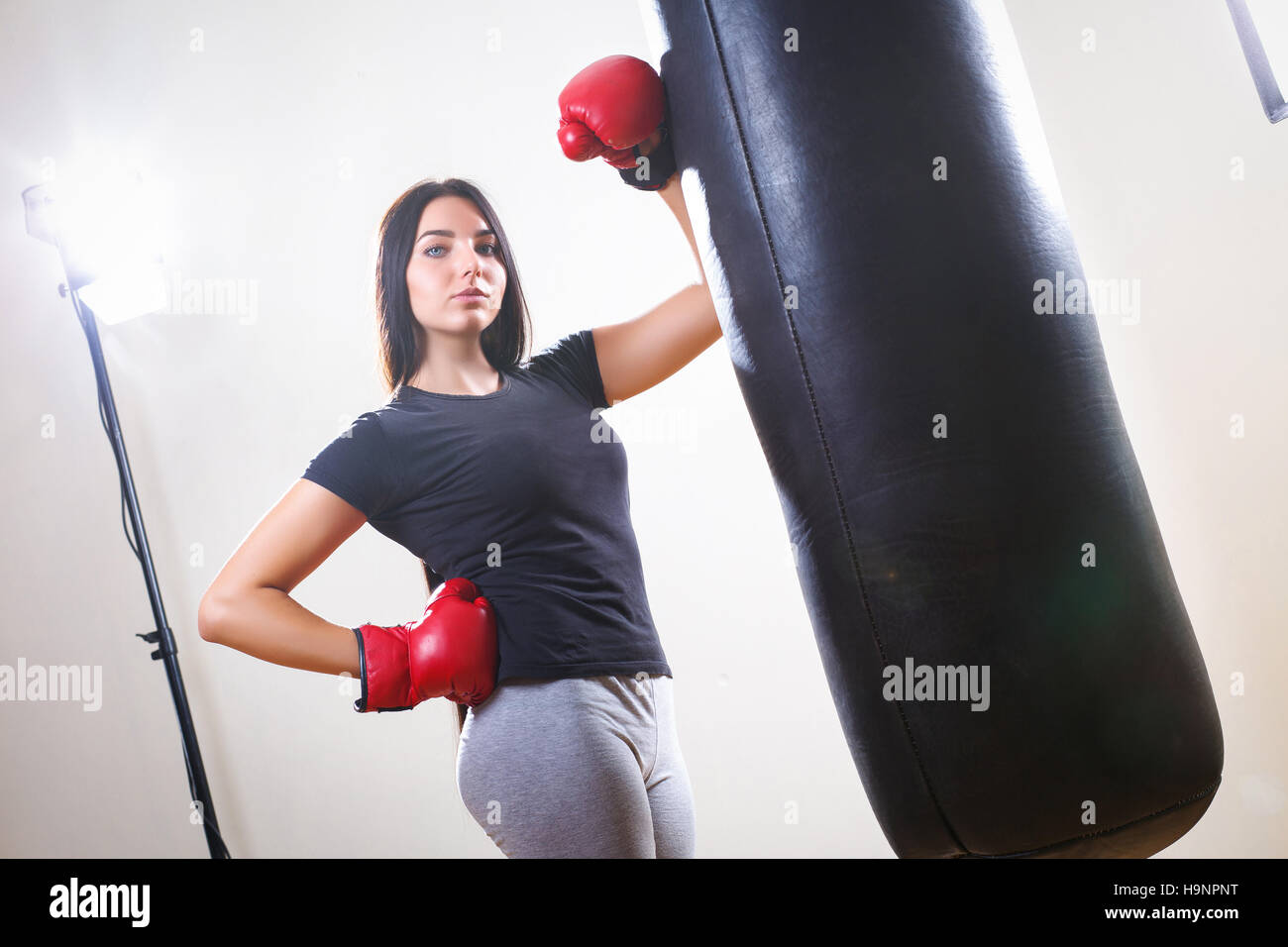 sports girl in boxing gloves and body punching bag Stock Photo
