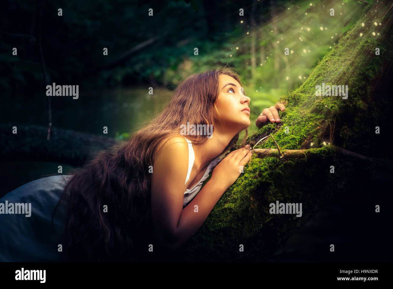 Beautiful girl with long hair in a mystical forest Stock Photo - Alamy