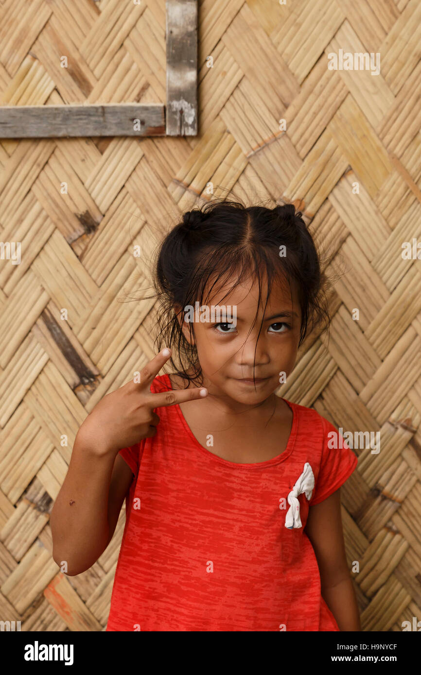 Puerto Princesa,Philippines-October 19,2016: Little girl plays in front of family trade on October 19, Palawan,Philippines. Stock Photo