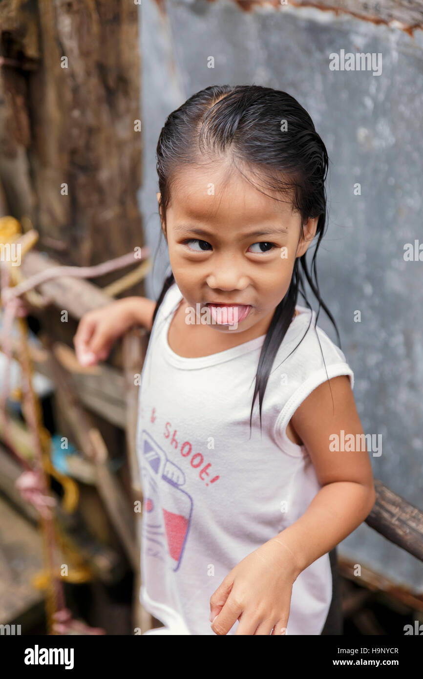 PUERTO PRINCESA,PHILIPPINES-OCTOBER 19,2016: Little girl plays in front of family trade on October 19, Palawan,Philippines. Stock Photo