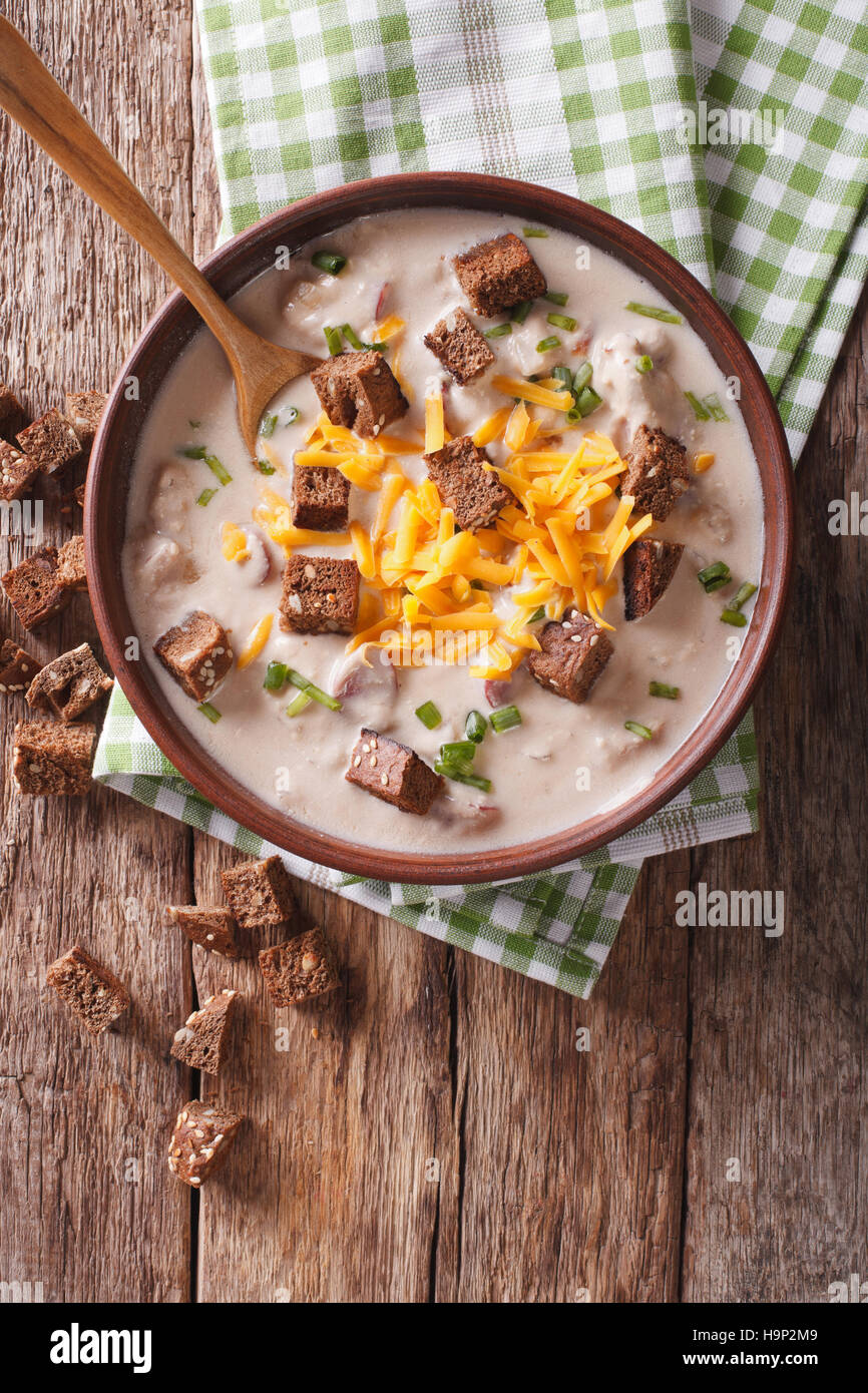 Bavarian beer soup with cheese and bacon close up in a bowl on the table. Vertical view from above Stock Photo