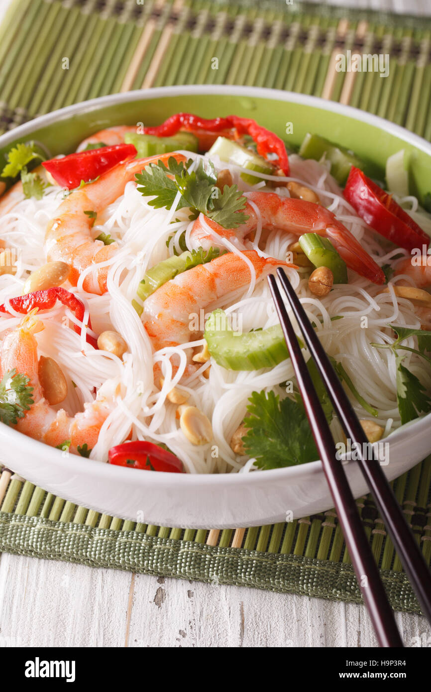 Thai salad with glass noodles, prawns and vegetables in a bowl close-up. vertical Stock Photo