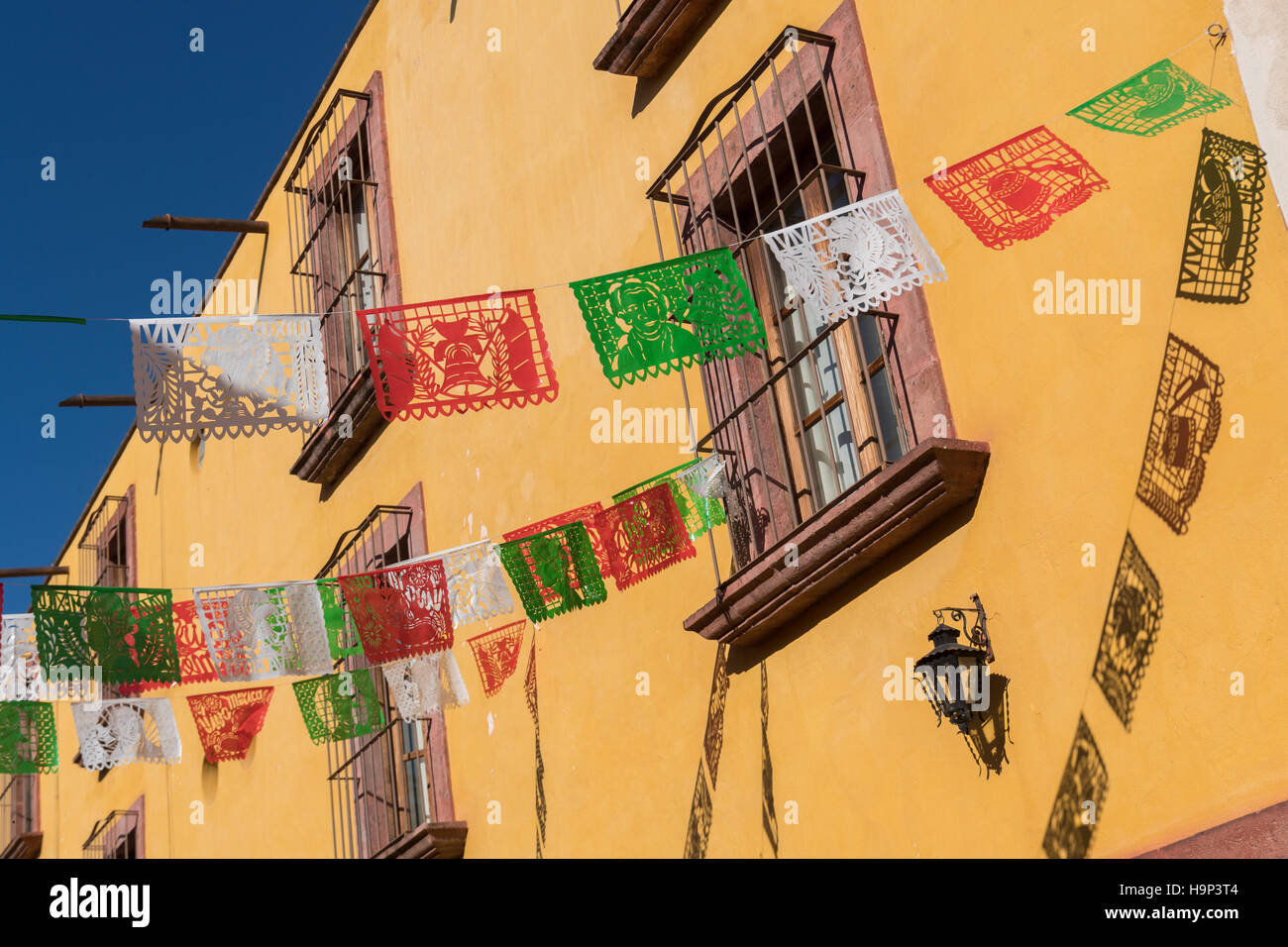 Mexican Papel Picado banners decorate a street during a festival in San Miguel de Allende, Guanajuato, Mexico. Stock Photo