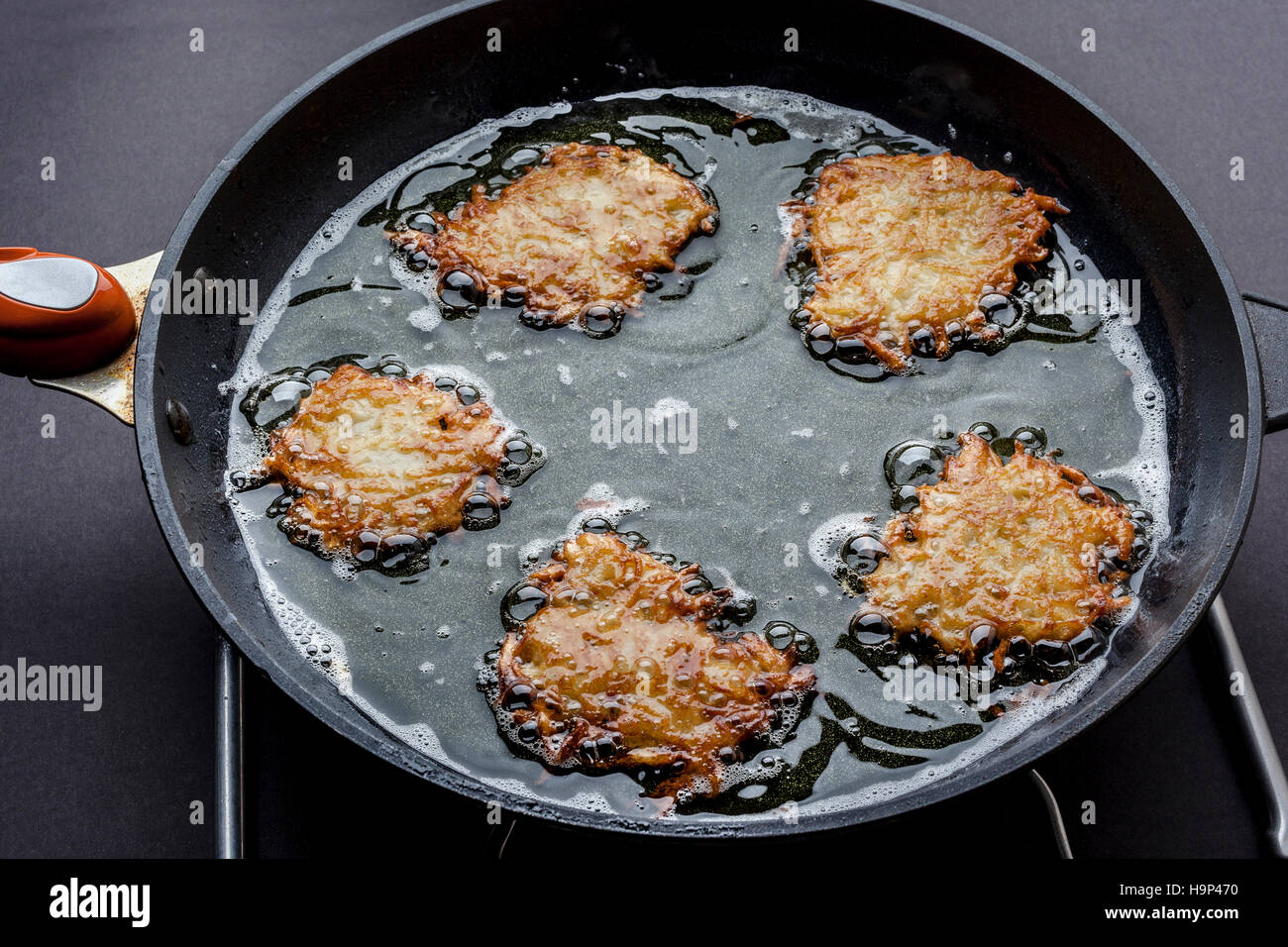 Frying latkes with ready side up in deep oil on the pan from side Stock