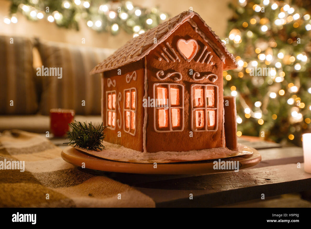 Homemade gingerbread house on background room decorated for Christmas