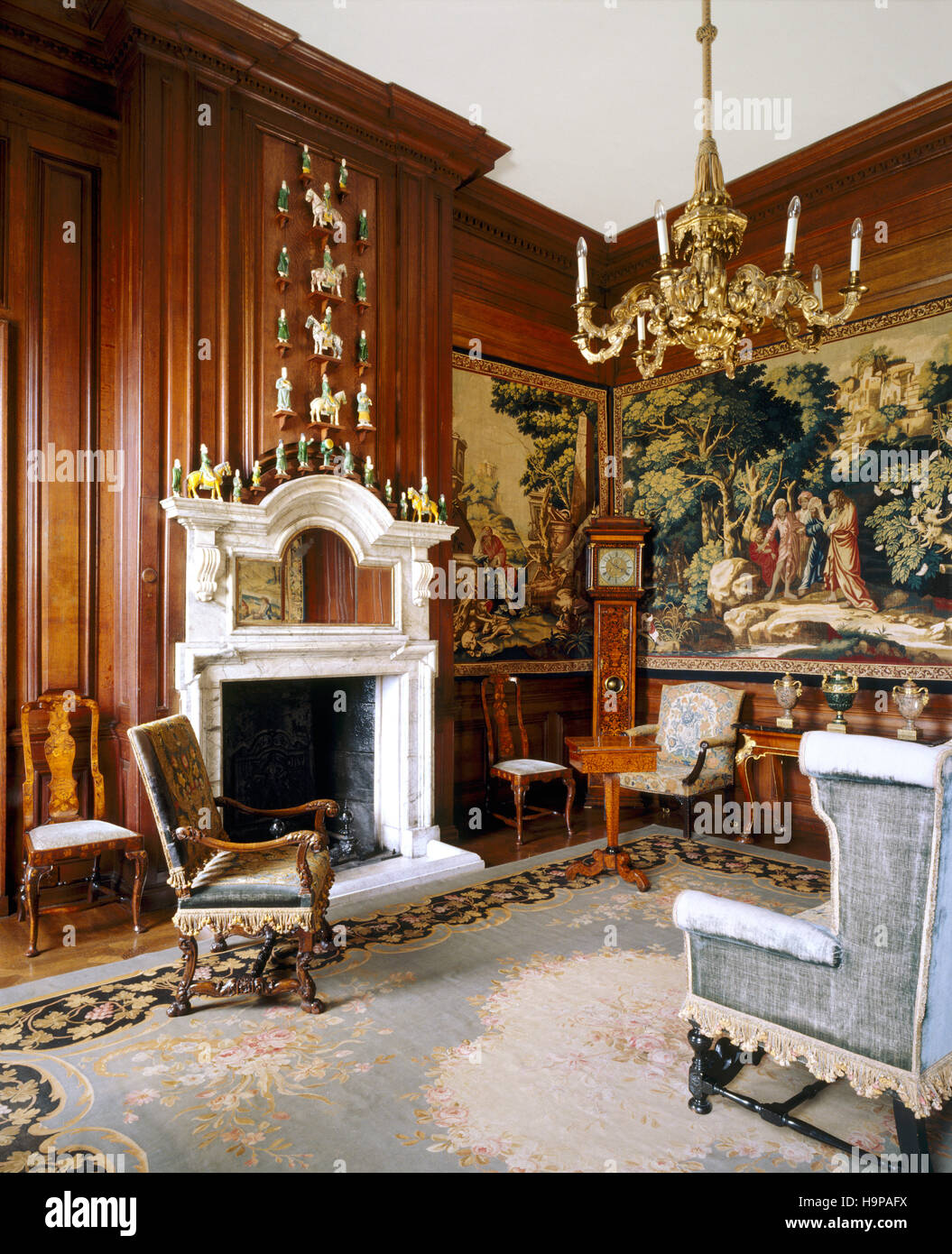 View of the Tapestry room at Antony House showing smoky grey marble chimney-piece, late C17th style settee with oak frame, Stock Photo