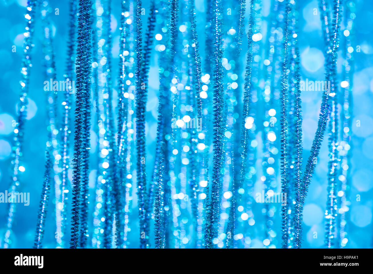 Christmas defocused background with light blue foil tinsel Stock Photo