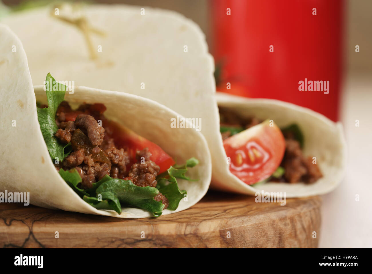 homemade tortilla with beef, frillice and vegetables and drink on wooden board Stock Photo