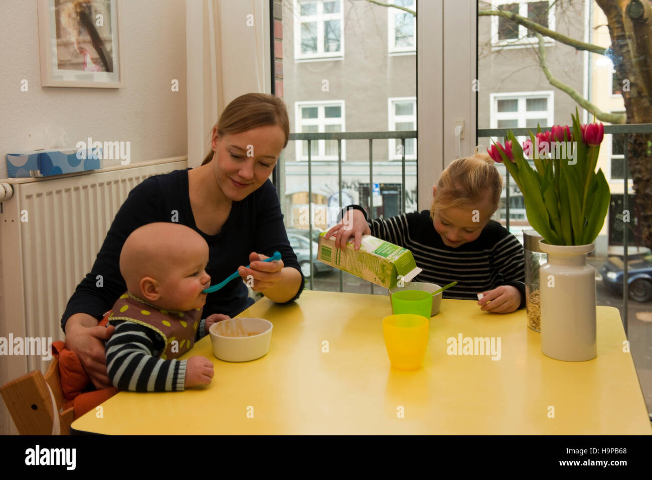 Deutschland, junge Frau mit Kindern in der Küche Stock Photo