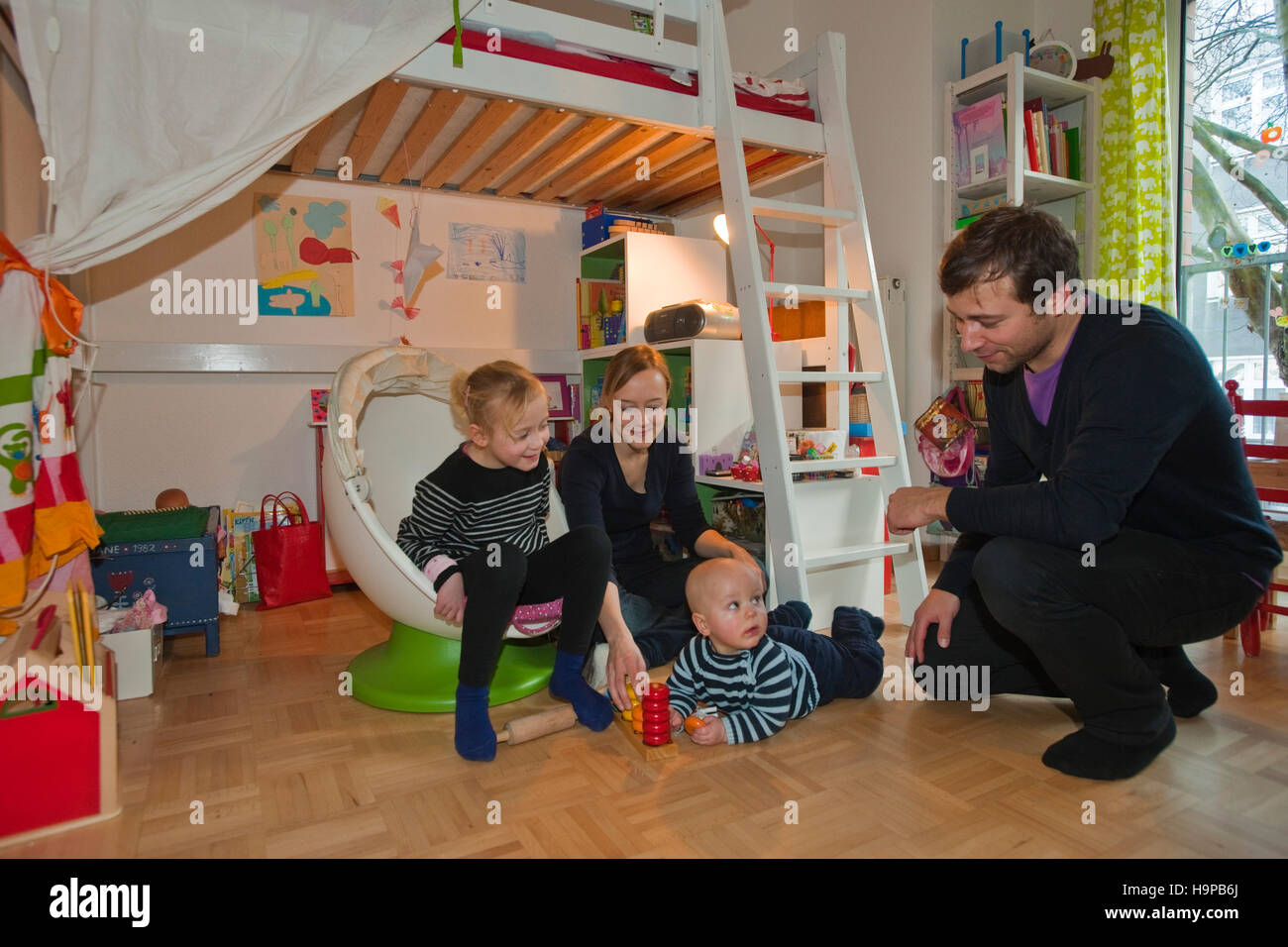 Deutschland, junge Familie mit Kindern in Kinderzimmer Stock Photo