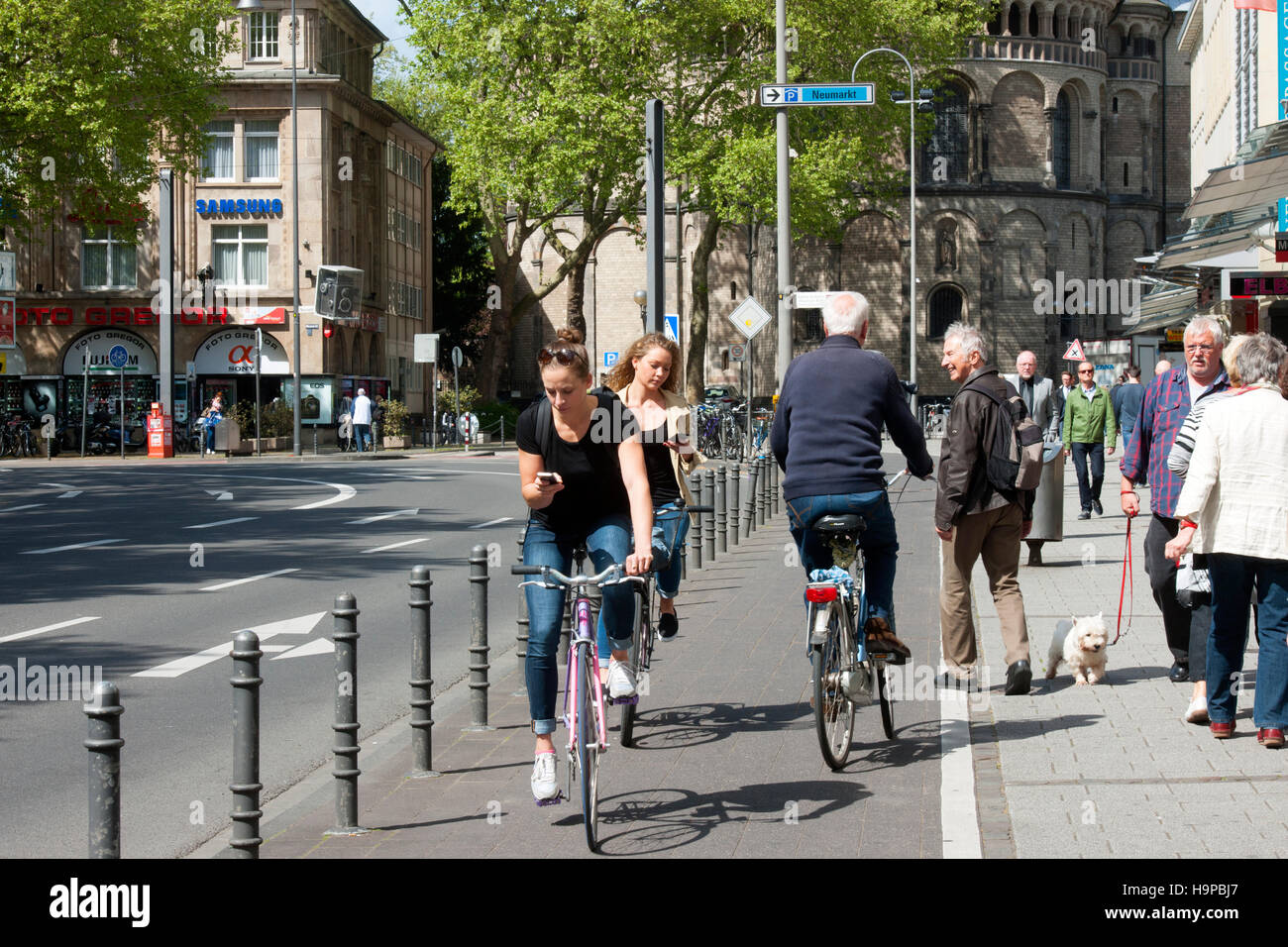 Deutschland, Köln, junge Frauen mit Smartphone auf Fahrrad Stock Photo ...