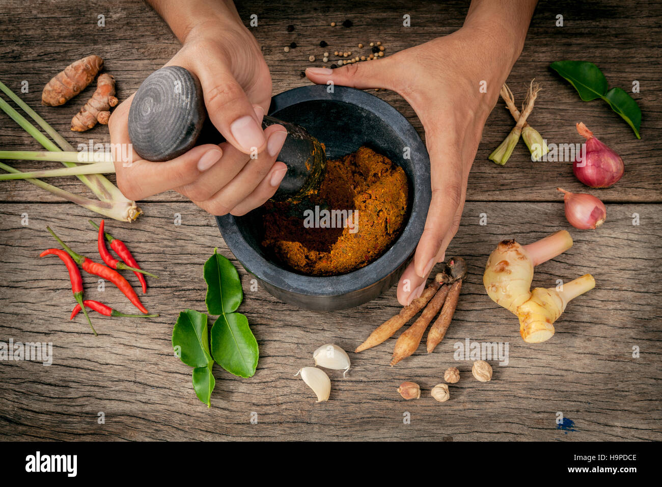 The Women hold pestle with mortar and spice red curry paste ingr Stock Photo