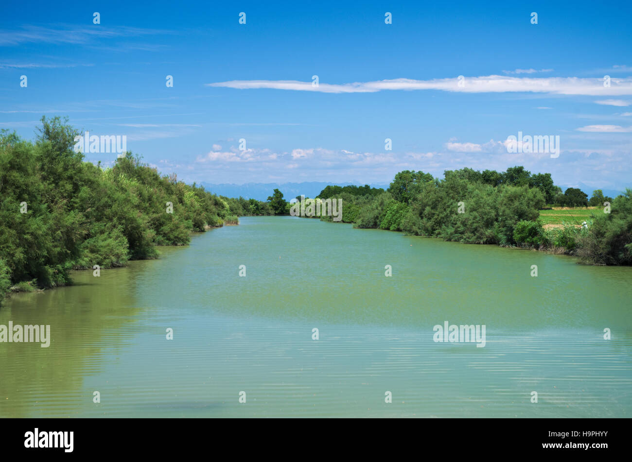 Summer view of river Lemene in the Venetian Plain with the Alps mountains in the background Stock Photo