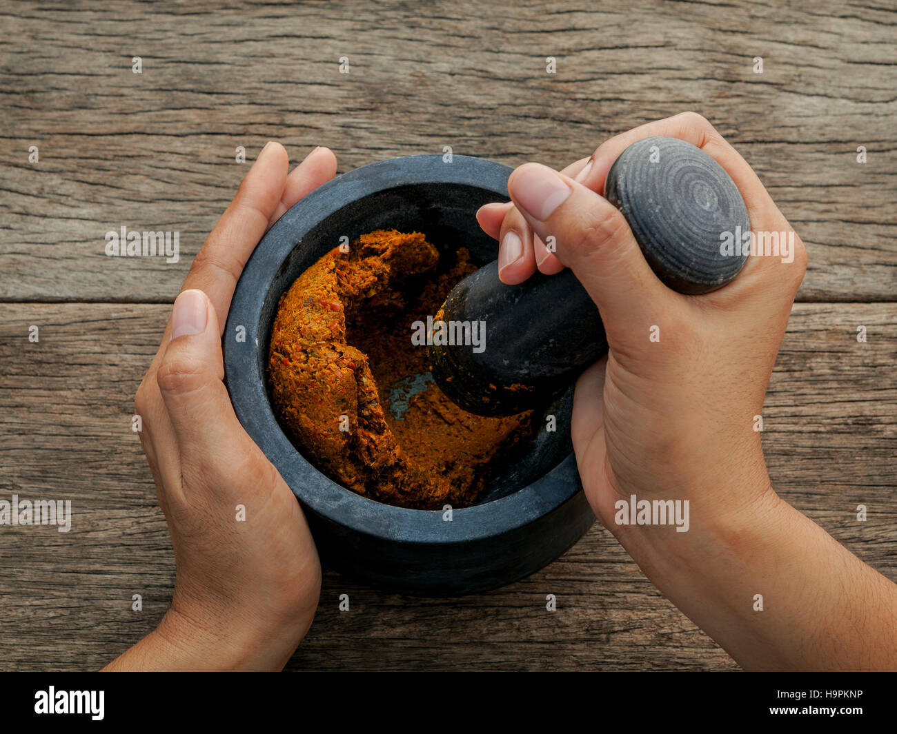 The Women hold pestle with mortar and and spice red curry paste Stock