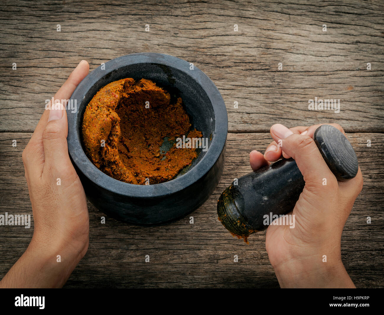 The Women hold pestle with mortar and and spice red curry paste Stock