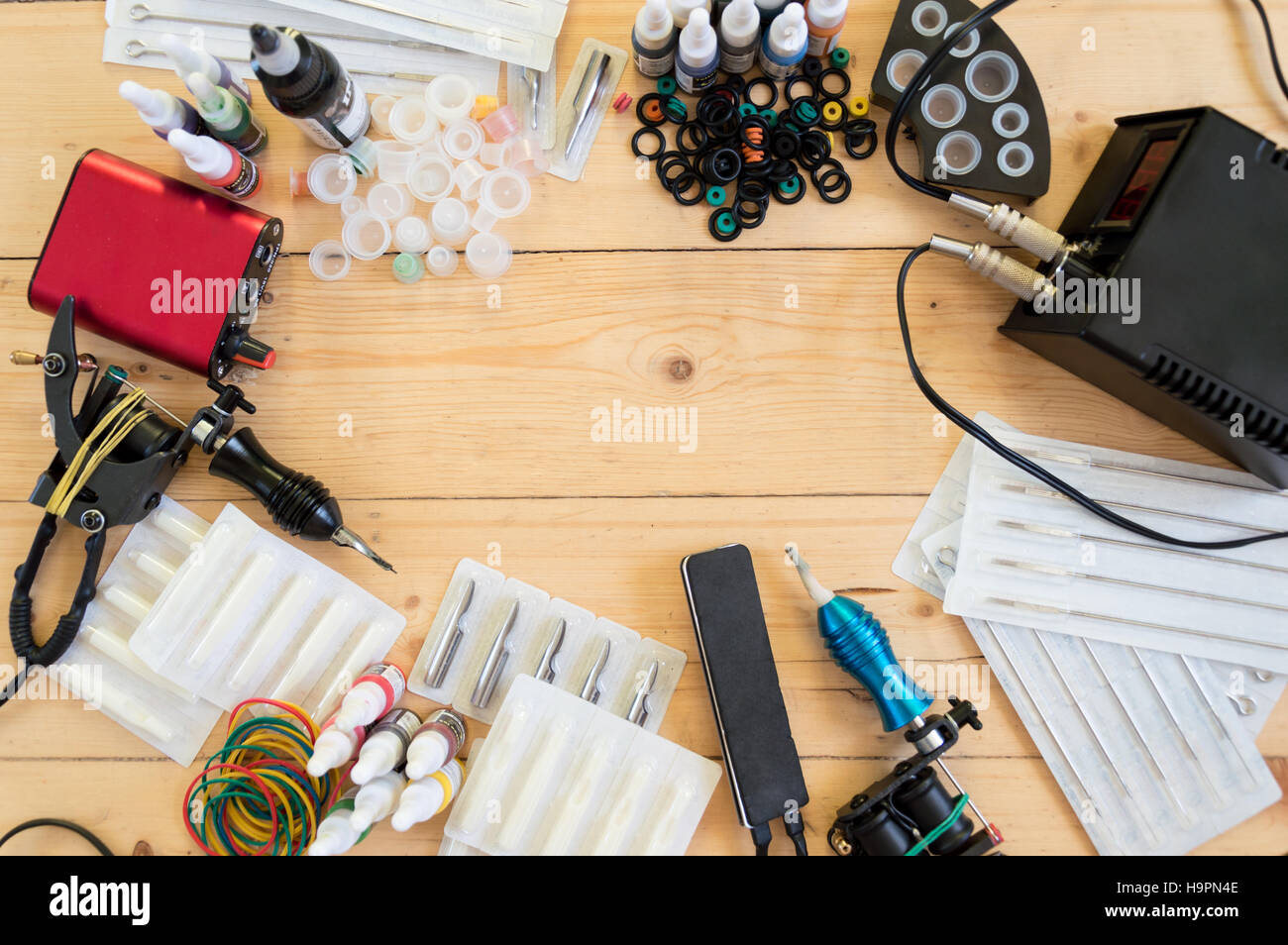 Tattoo machines and equipment on the wooden background Stock Photo - Alamy