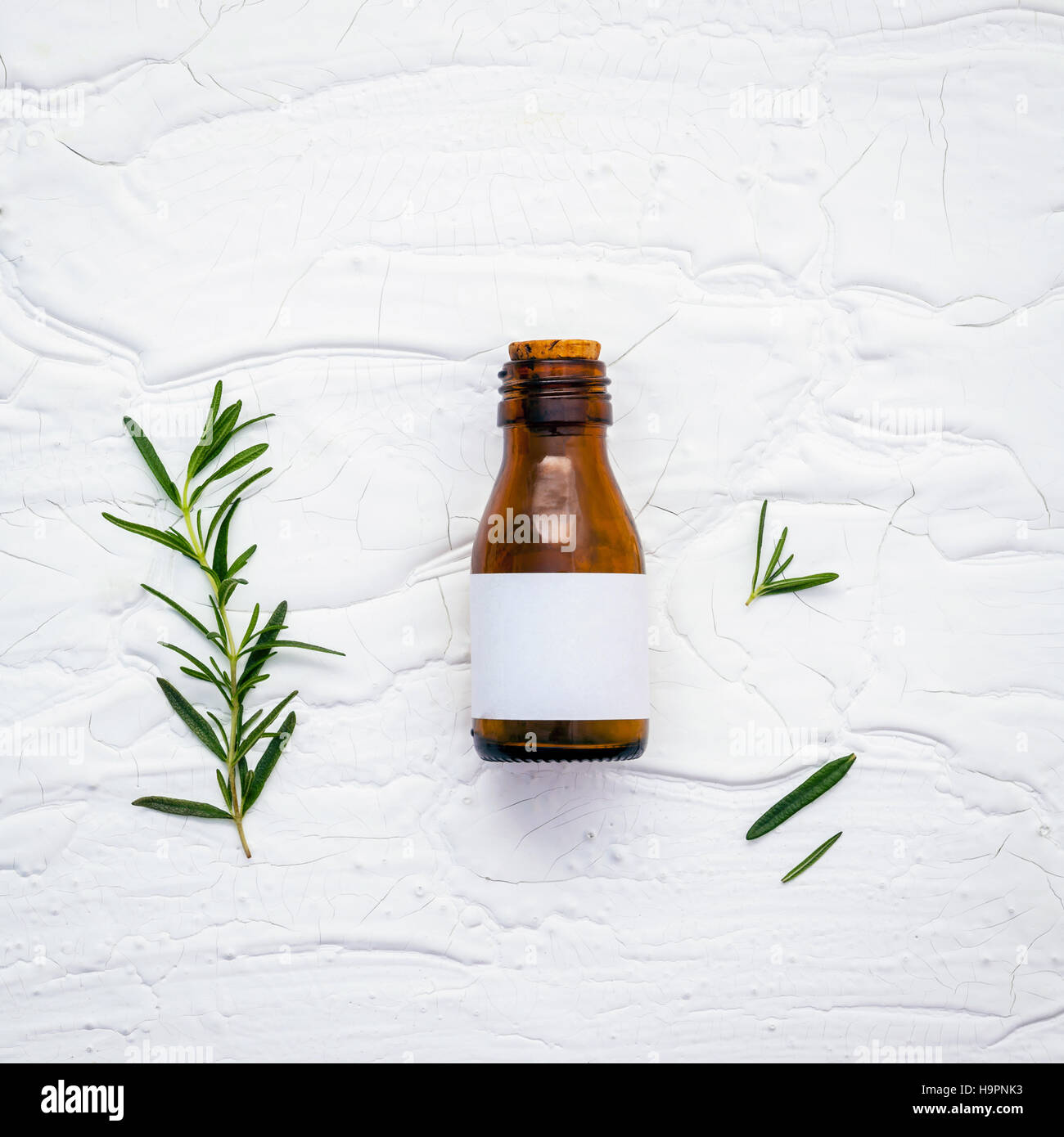 Fresh branch of rosemary  with bottle essential oil setup on whi Stock Photo