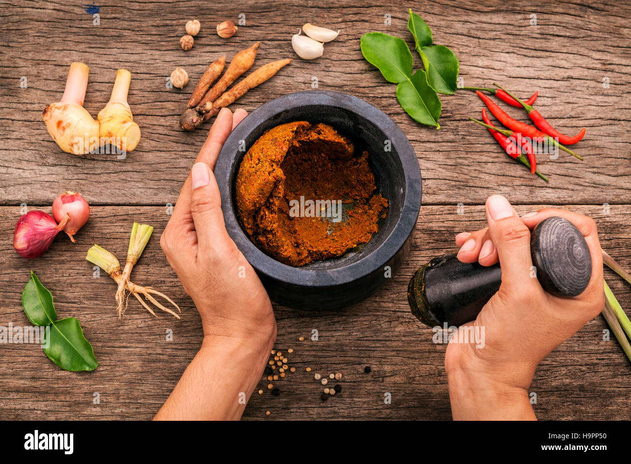 The Women hold pestle with mortar and spice red curry paste ingr Stock Photo