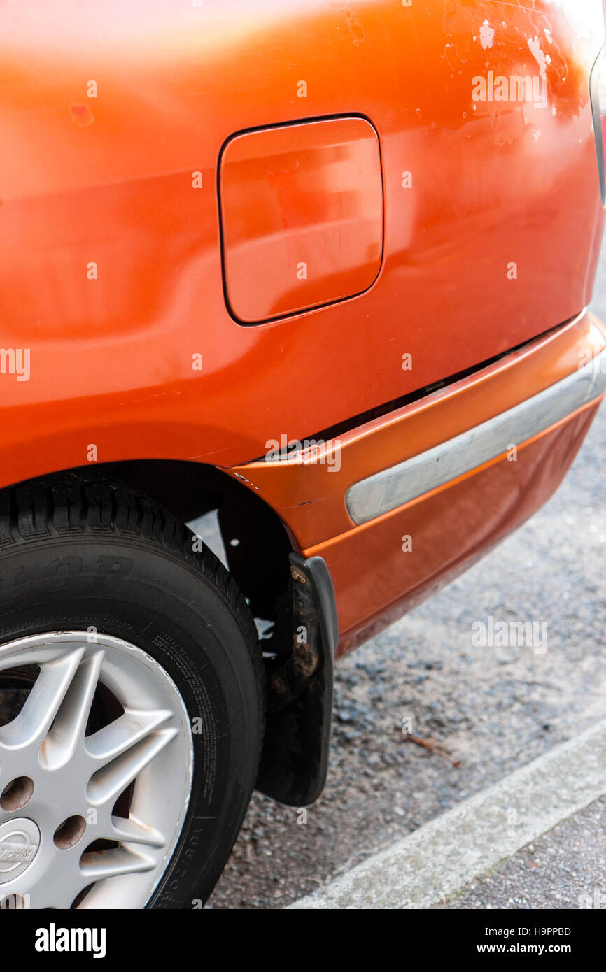Orange Nissen Primera car. After collision. Bumper on side crumpled and