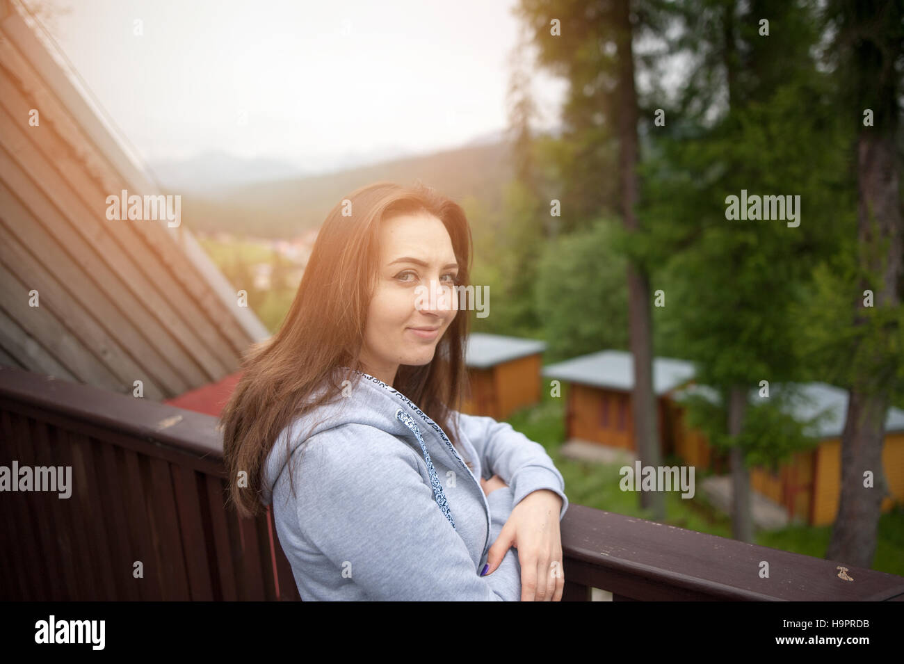 beautiful brunette teen girl with long hair leaning on railing Stock Photo