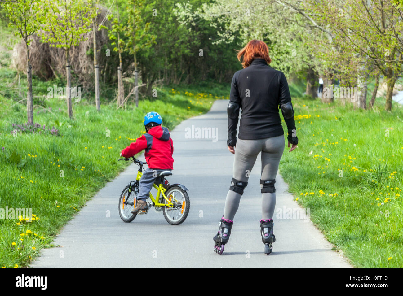 Mother and child on a bicycle, toddler ride a bike on a cycle path