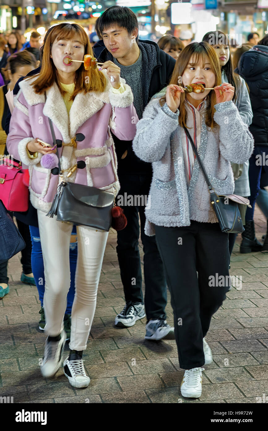 Seoul, South Korea March 14, 2016 Korean girls tasting street food