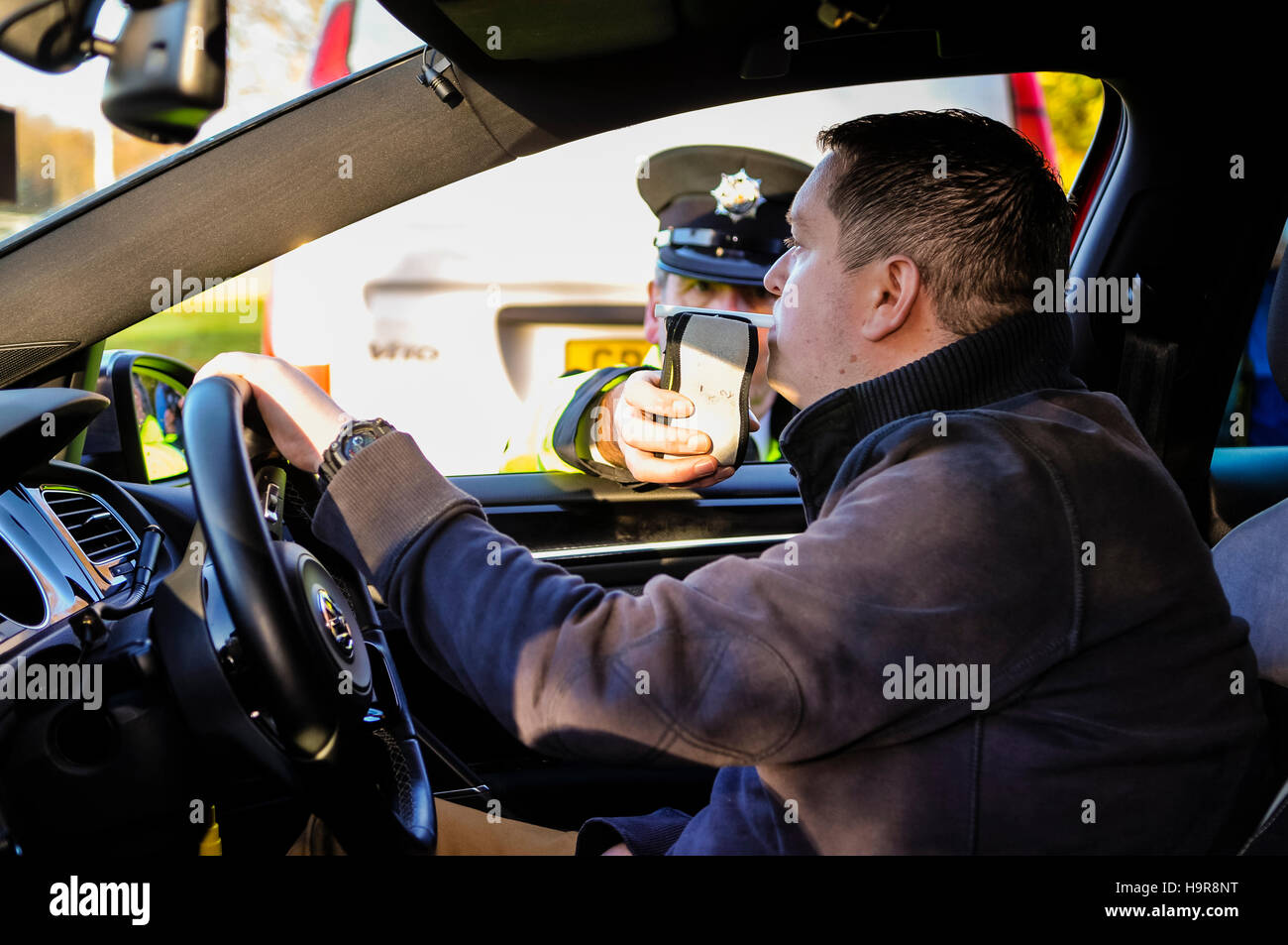 Belfast, Northern Ireland. 24 Nov 2016 - A driver blows into a roadside handheld alcohol breath tester breathalyser while it is held by a traffic police officer. Credit:  Stephen Barnes/Alamy Live News Stock Photo