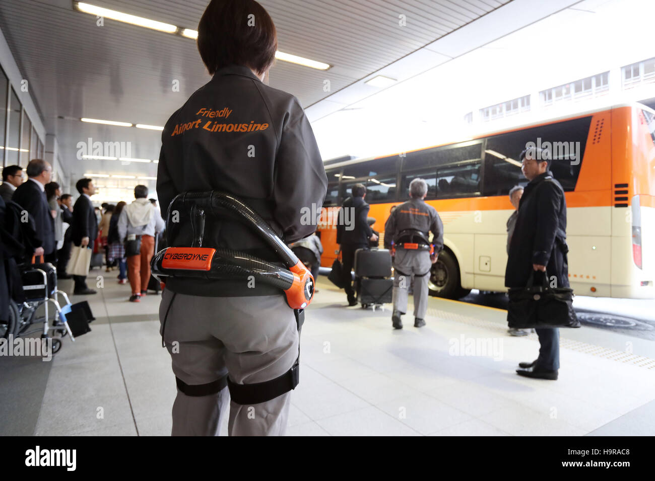 Tokyo, Japan. 24th Nov, 2016. Airport Limousine bus service employee wearing robot suit Hybrid Assistive Limb (HAL), developed by Cyberdyne load tourists' suitscases into an airport shuttle bus at the Haneda airport in Tokyo on Thursday, November 24, 2016. The HAL is designed to learn the user's motion and assist their movements. It can be used by workers to reduce strain on carrying heavy objects by supporting the user's back. Credit:  Yoshio Tsunoda/AFLO/Alamy Live News Stock Photo