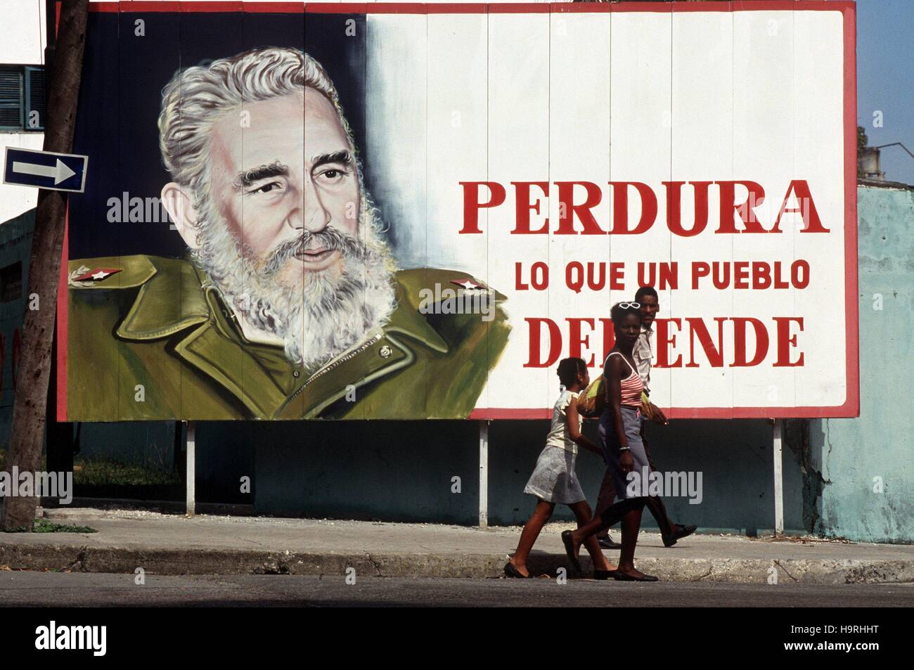 Eine Gruppe Jugendlicher geht an einer Plakatwand mit einem überdimensionalen Bildnis des Staats- und Parteichefs Fidel Castro vorbei, aufgenommen Ende 1996 in Kubas Hauptstadt Havanna. | Verwendung weltweit/picture alliance Stock Photo