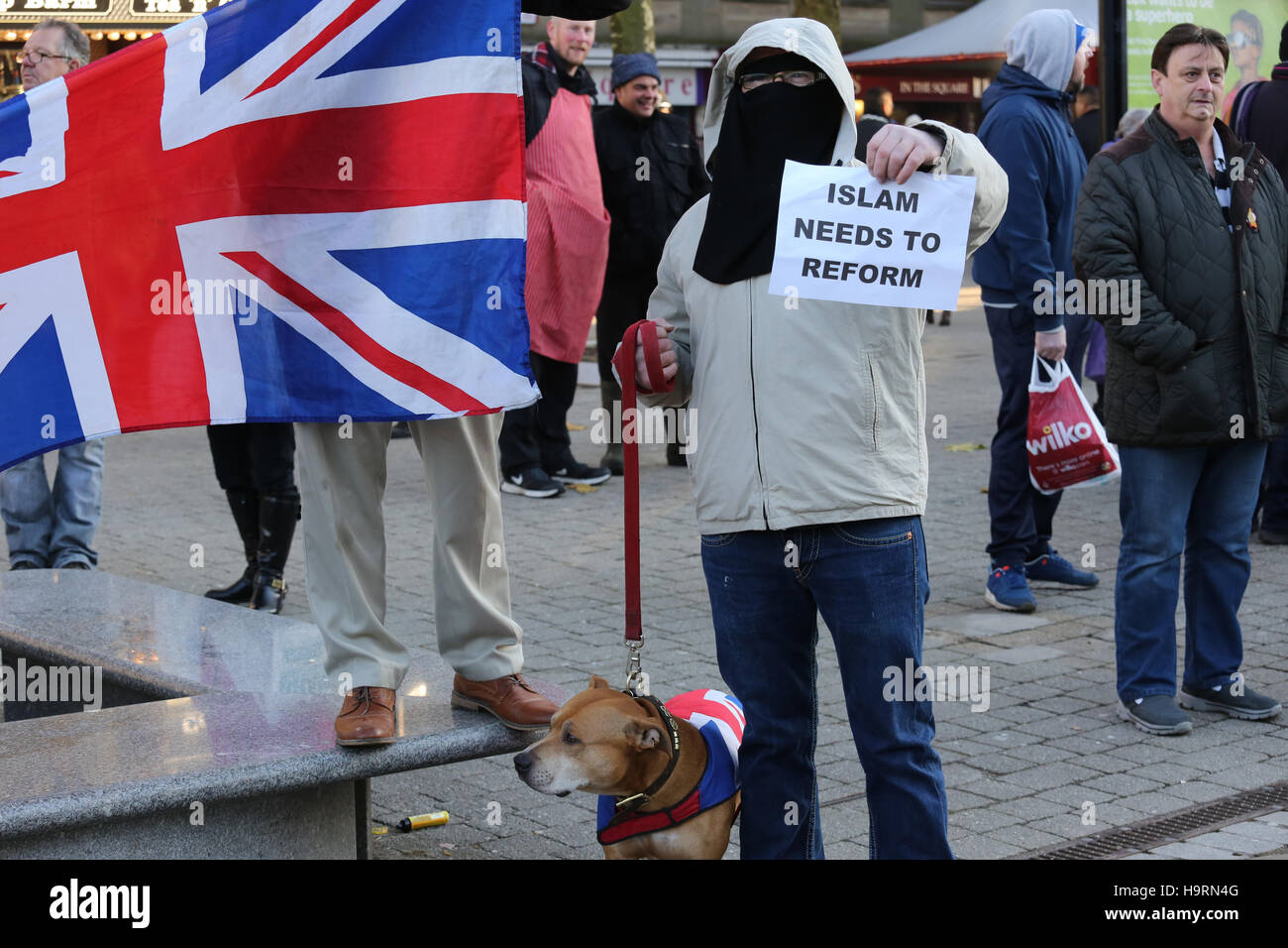 Bolton, Lancashire, UK. 26th November, 2016. A man stood with a staffordshire Bull Terrier wearing a Union Jack coat, Bolton, Lancashire, UK. 26th Nov, 2016. Credit:  Barbara Cook/Alamy Live News Stock Photo