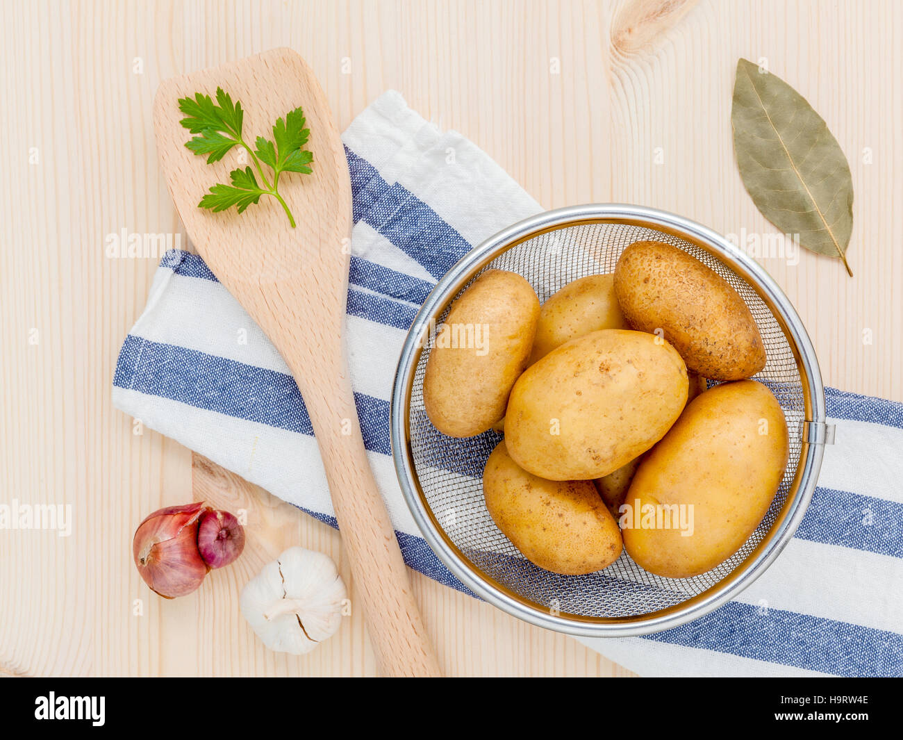 Fresh organic potatoes in basket with herbs garlic,shallot ,pars Stock Photo